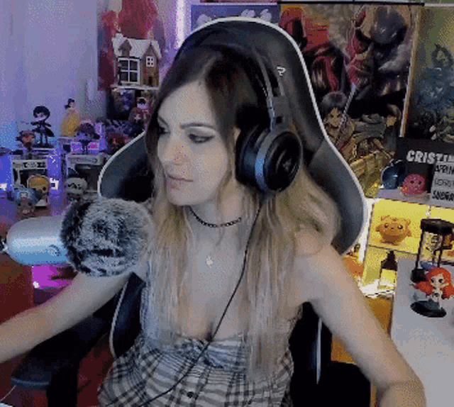 a woman wearing headphones sits in front of a sign that says ' cristal ' on it