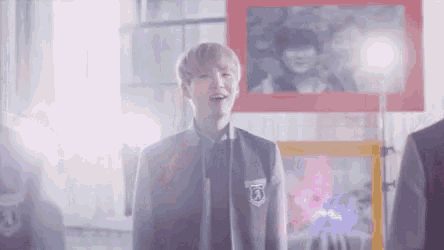 a young man wearing a varsity jacket and a badge with the letter a on it
