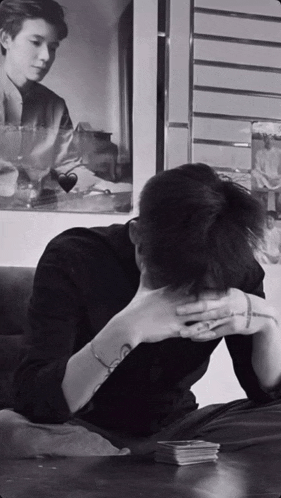 a man sits at a table with his head in his hands