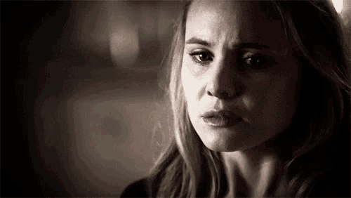 a woman is crying and looking at the camera in a black and white photo .