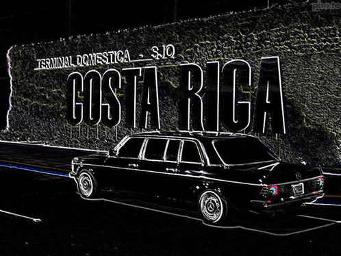 a black car is parked in front of a wall that says costa rica