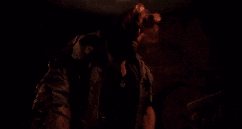 a man with horns on his head is standing in the dark