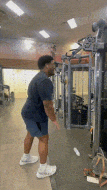 a man is using a machine in a gym while wearing headphones .