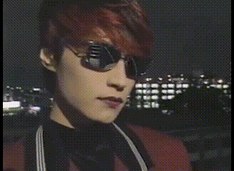 a close up of a woman wearing sunglasses and a black jacket