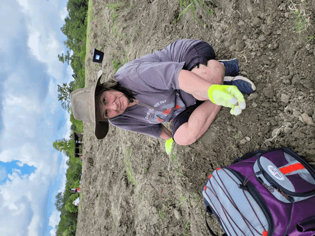 a woman kneeling in the dirt wearing a t-shirt that says " i 'm not fat "