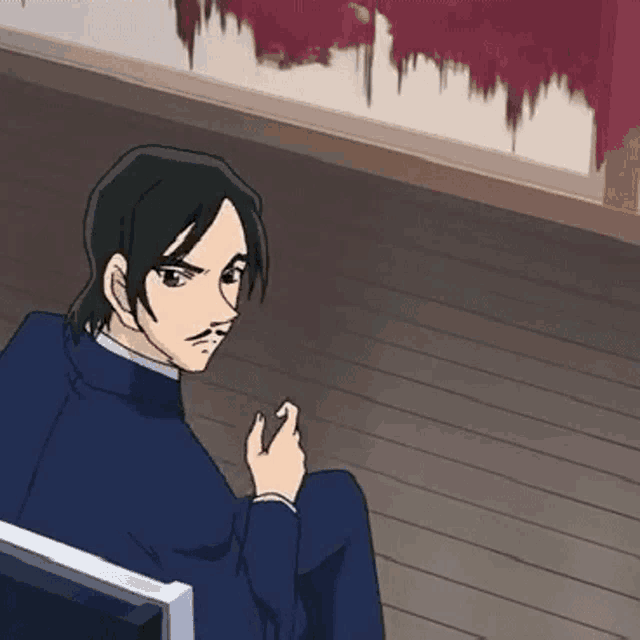 a man with a mustache is sitting on a wooden floor in a chair .