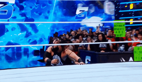 a man in a wrestling ring holds a sign that says where are you