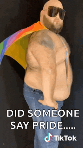a fat man wearing sunglasses and a rainbow flag says " did someone say pride .... "