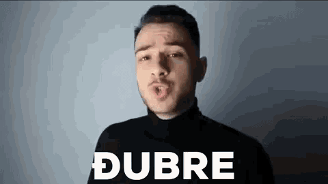 a man in a black turtleneck is making a funny face and saying the word dubre in white letters .