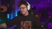 a man wearing headphones is holding a red boxing glove in front of a microphone .