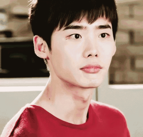 a close up of a young man 's face wearing a red sweater .