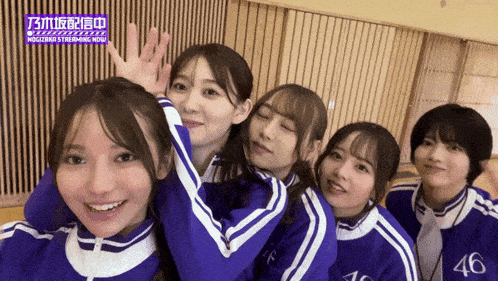 a group of asian girls are posing for a picture with the number 46 on their jackets