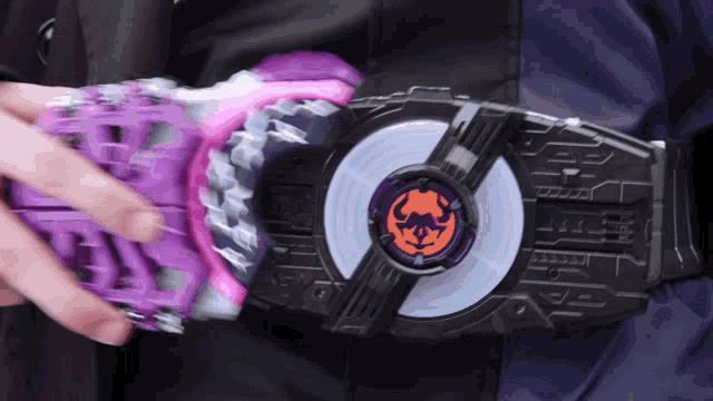 a person is holding a purple and pink item with a circle on it