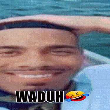 a close up of a man 's face with the word waduh written above it