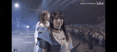 two girls on a stage with the words mygo ave mujica on the bottom right