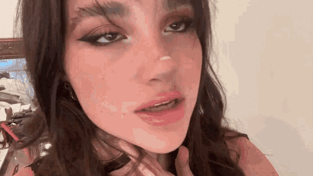 a close up of a woman 's face with a white spot on her nose .