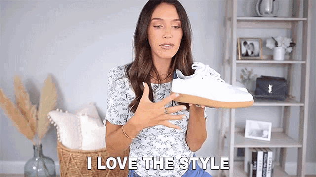 a woman is holding a pair of white shoes and says i love the style