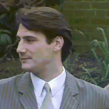 a man in a suit and tie is smiling and looking at the camera