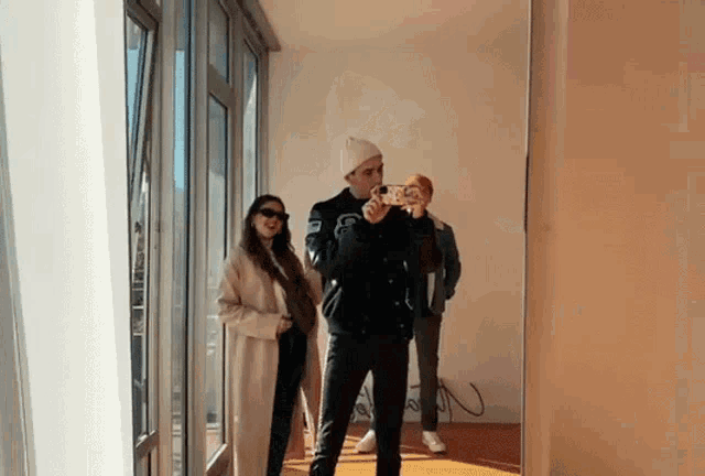 a man is taking a picture of himself and two other people