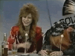 a couple of people sitting at a table with bottles of alcohol and glasses of beer .