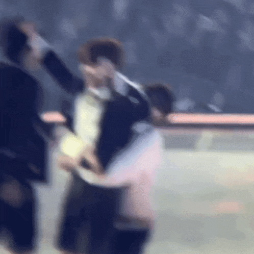 a blurry picture of a man in a tuxedo holding a woman