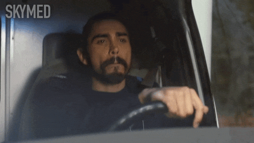 a man with a beard is driving an ambulance with skymed written on the screen