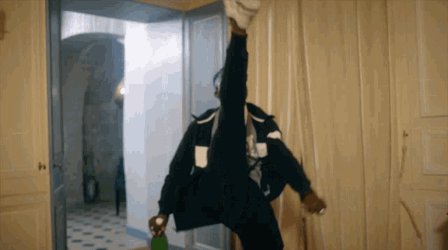 a person is doing a split while holding a green bottle