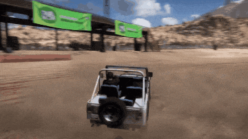 a jeep is driving down a dirt road under a bridge with a green banner that says marathon