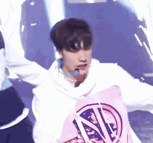 a young man wearing a pink shirt with the letter n on it