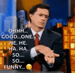 a man in a suit and tie is making a funny face while talking on a television show .