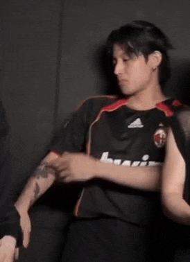 a man wearing a black bwin jersey is being held by another man