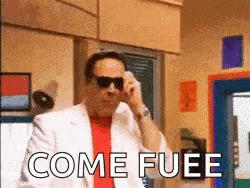 a man wearing sunglasses and a white suit is talking on a cell phone and the words come fuee are visible .