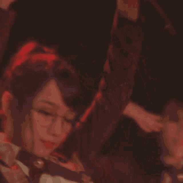 a close up of a woman wearing glasses and a red tie .
