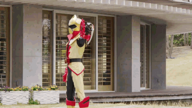 a man in a superhero costume is standing in front of a building .