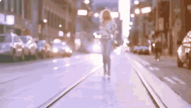 a blurry picture of a woman walking down a city street at night