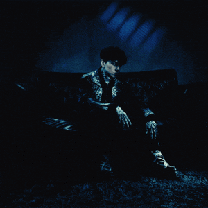 a man sitting on a couch in a dark room