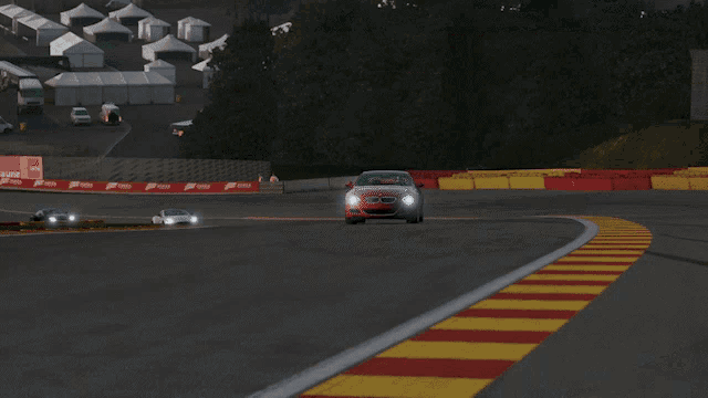 a red bmw is driving down a curvy road