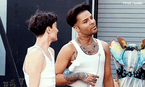 two men are standing next to each other and one of them has a tattoo on his neck that says " i love you "