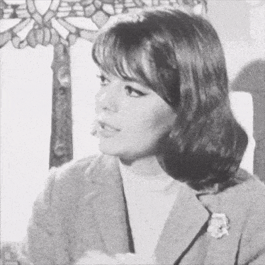 a black and white photo of a woman with a flower in her hair