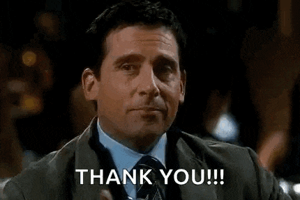 a man in a suit and tie is holding a drink in his hand and saying `` thank you '' .