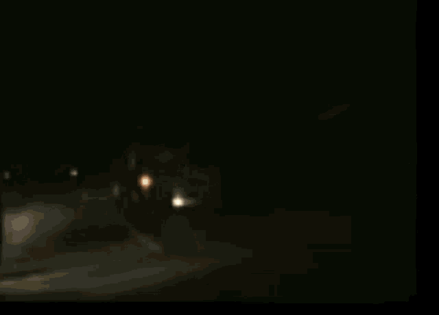 a truck is driving down a road at night with a lot of lights on .