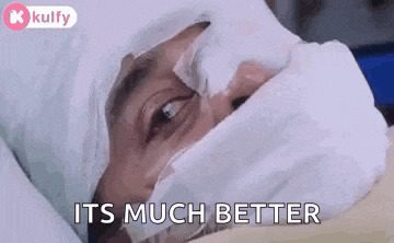 a man is laying in a hospital bed with a bandaged head and a mask on his face .