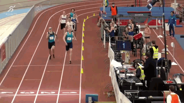 a group of athletes are running on a track with a sign that says dima on it
