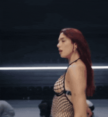 a woman with red hair is dancing in front of a group of dancers