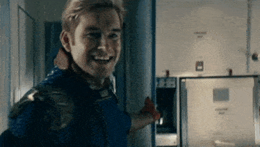 a man in a superhero costume is pointing at the camera and smiling