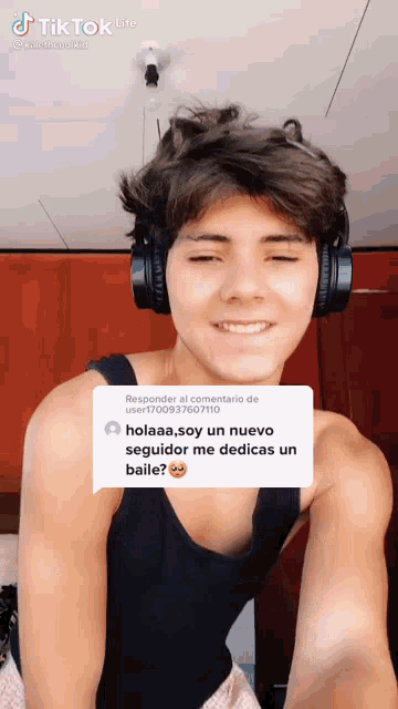 a young man wearing headphones and a black tank top with a reply from a user