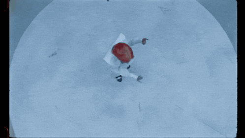 a person in a red hat is laying on a snowy surface