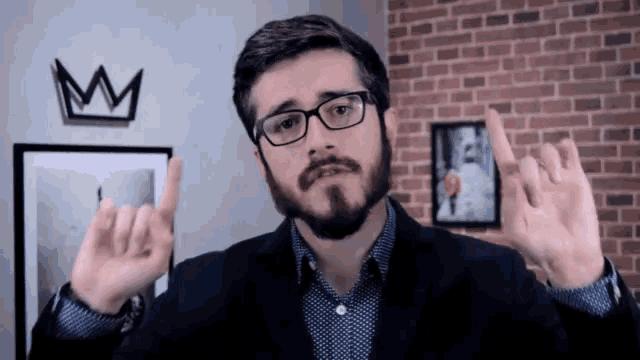 a man with glasses and a beard making a funny face
