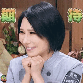 a woman is smiling with her hands on her chin while wearing a military uniform .