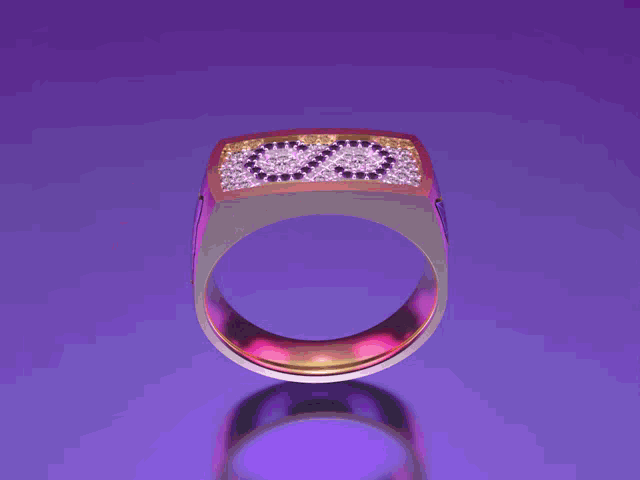 a pink ring with a black cat on it is on a purple surface